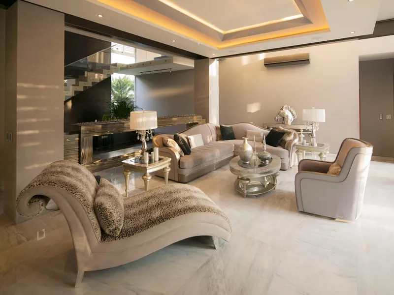 Sala de Casa AG con piso de mármol y plafón iluminado