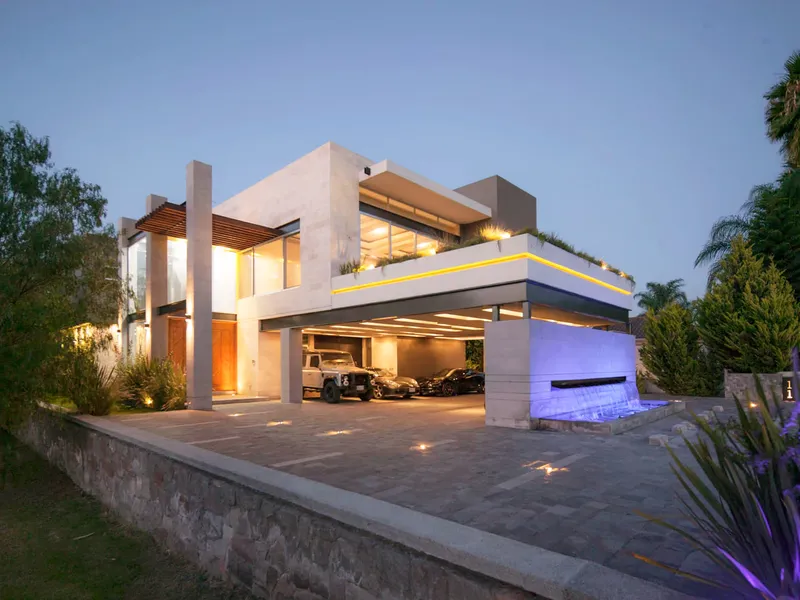 Fachada de Casa AG en Balvanera, Querétaro, iluminada al anochecer