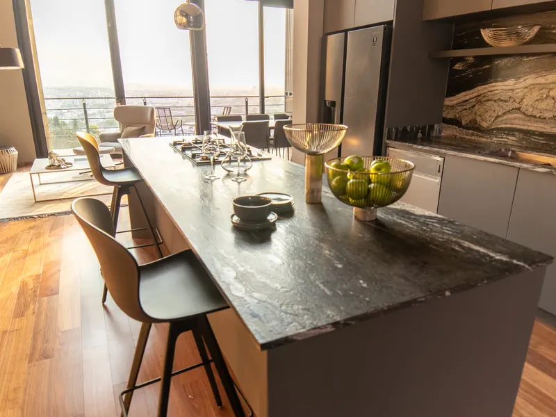 Cocina de Panorámica Townhouses con isla de cubierta de piedra oscura